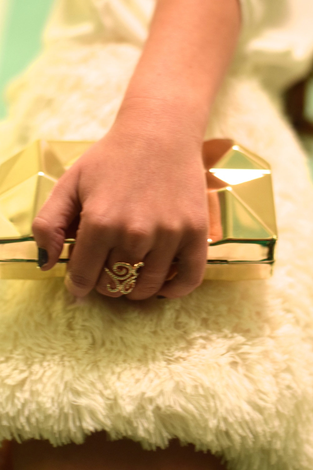 gold clutch with white feather skirt